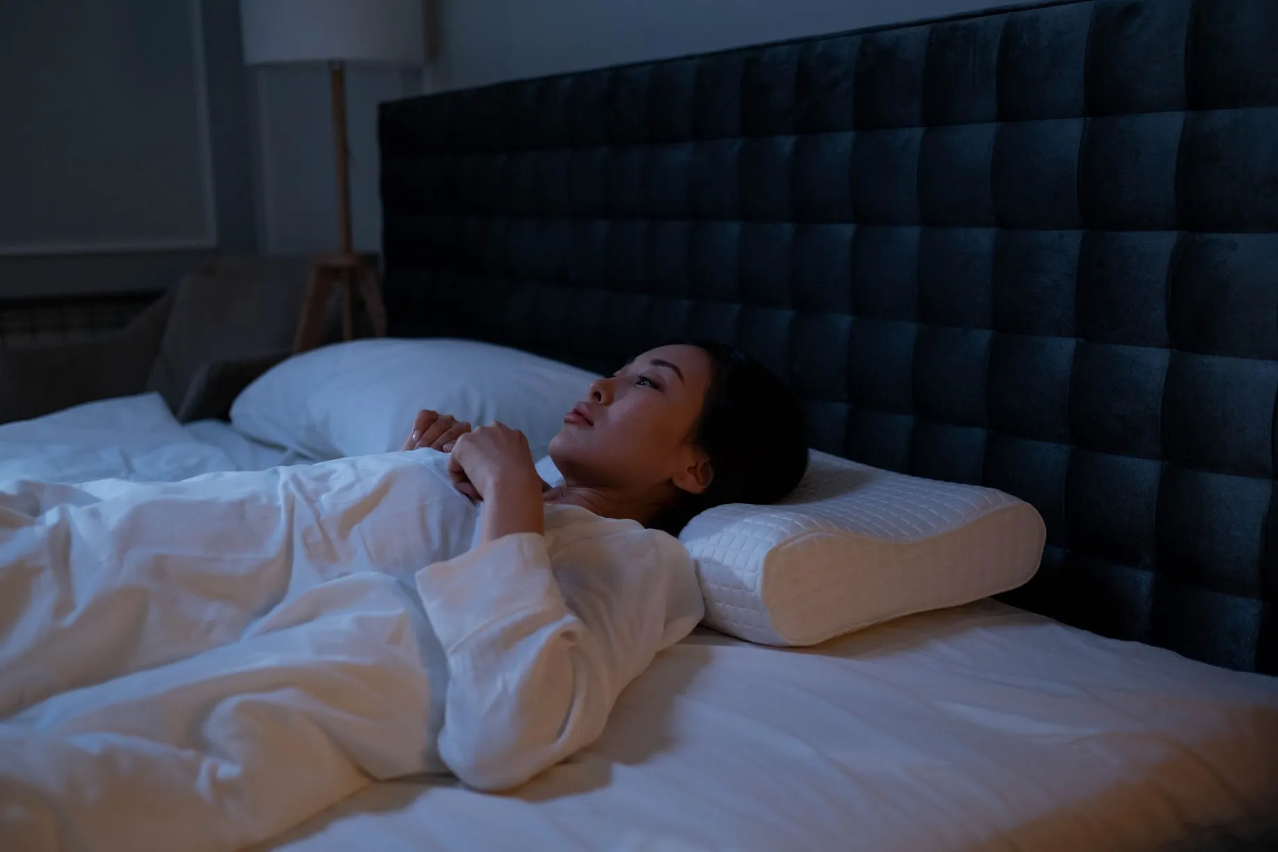 A woman lying awake in bed at night, staring, unable to sleep